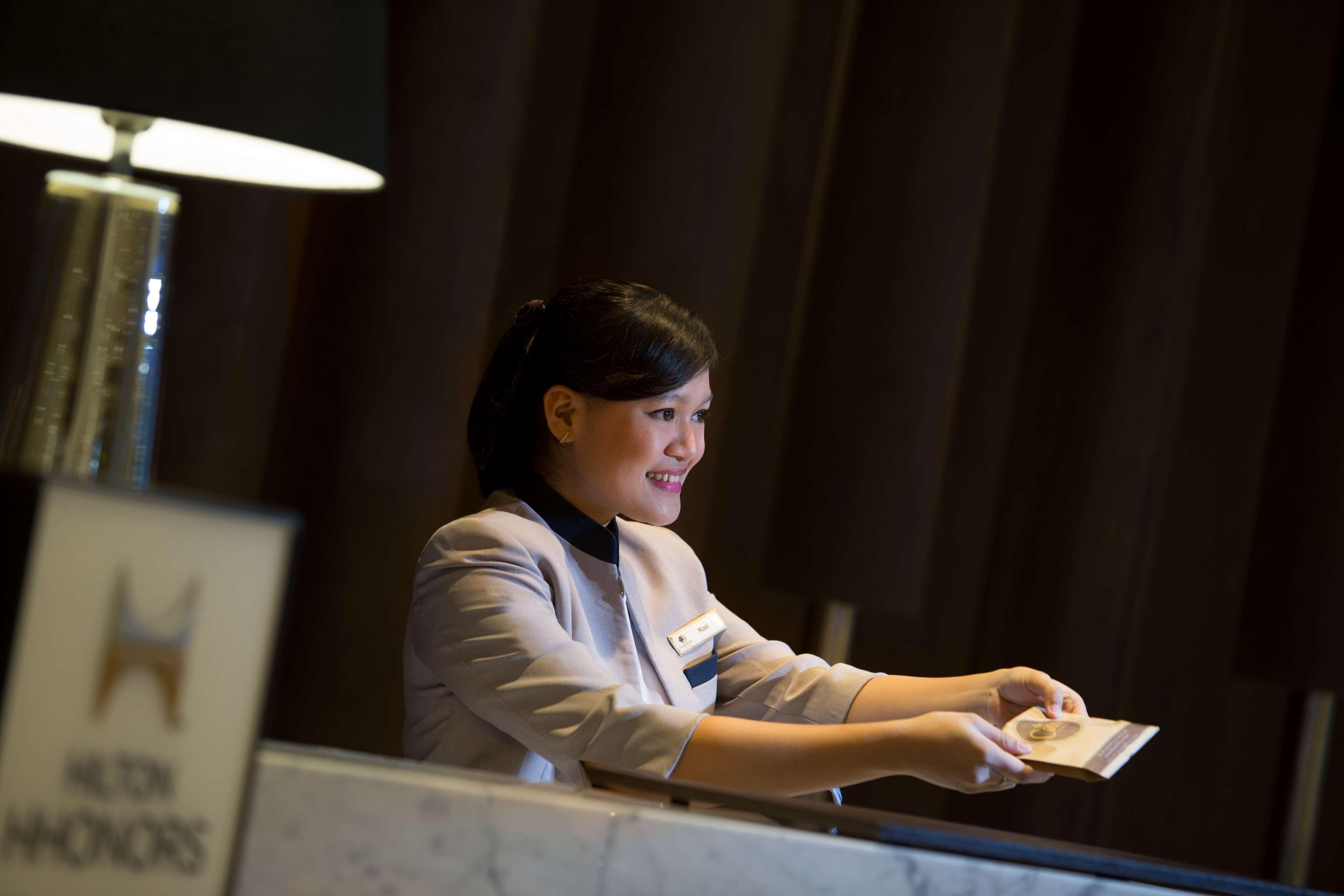 Doubletree By Hilton Jakarta - Diponegoro Kültér fotó A hotel receptionist at work